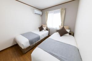 a bedroom with two beds and a window at The CATAN 伏見稲荷 in Kyoto