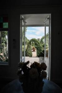 una puerta abierta con vistas al jardín en The Merribee, Villa Botanica, en Numba 1 foto más