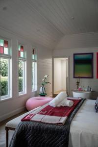 1 dormitorio con 1 cama con lavabo y ventanas en The Merribee, Villa Botanica, en Numba