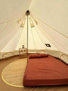 a tent with a red bed in a room at Bunihayu Forest in Peuteuy