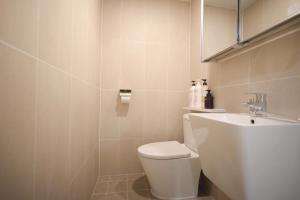 a white bathroom with a toilet and a sink at Manso Hostel in DDP in Seoul
