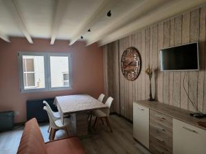 a living room with a table and chairs and a television at WHITE House in Burgos