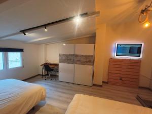 a bedroom with a bed and a desk and a tv at WHITE House in Burgos