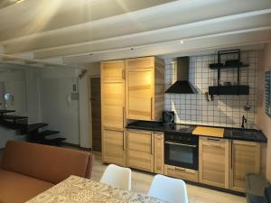 a kitchen with wooden cabinets and a table with chairs at WHITE House in Burgos +9 photos