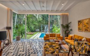a living room with orange furniture and a pool at La Verona by The Blue Kite - 2 & 3 BHK Villas in Assagao with Private Pool, Garden, Caretaker, Kitchen & Security in Assagao