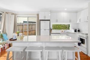 una cucina con armadi bianchi e piano di lavoro bianco di 2 Russell a Anglesea Altre 4 foto