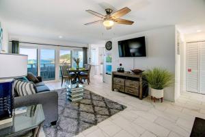 a living room with a couch and a ceiling fan at Beautiful Ocean Views Amazing Sunsets three pool! in Nazareth