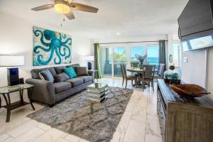 a living room with a couch and a table at Beautiful Ocean Views Amazing Sunsets three pool! in Nazareth