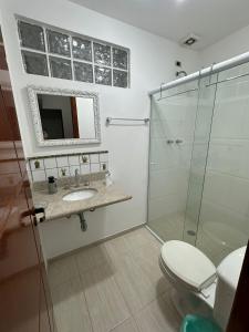 a bathroom with a shower and a sink and a toilet at Apartamento maravilhoso na Pitangueiras Guarujá in Guarujá