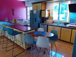 a kitchen with a table and chairs and a refrigerator at Le chapeau de Paille in Saint-Louis