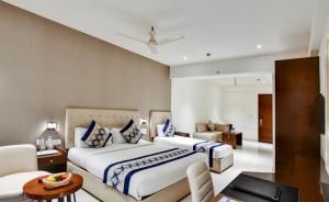 a bedroom with two beds and a living room at Manasa Inn, Tirupati in Tirupati