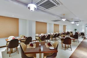 a dining room with tables and chairs in a room at Manasa Inn, Tirupati in Tirupati