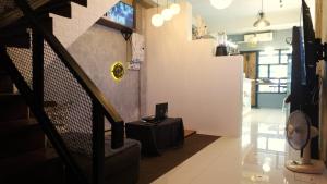 ein Zimmer mit einer Treppe und einem Tisch mit einem Ventilator in der Unterkunft 89 Bed & Studio Hostel in Godown