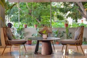 two chairs and a table and a table and chairs at Manasa Inn, Tirupati in Tirupati