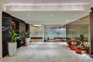 a lobby with potted plants in a building at Manasa Inn, Tirupati in Tirupati +28 photos