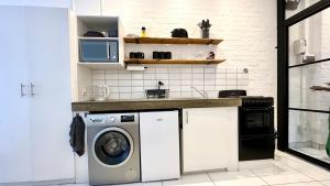 a kitchen with a washing machine and a microwave at Industrial CHIC Apartment 113 - Luxury City Escape, Washing Machine & Fast WiFi in Johannesburg