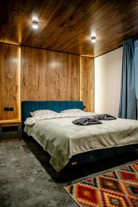 a bedroom with a blue bed with a wooden wall at DanRock in Yablunytsya