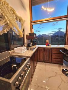 a kitchen with a sink and a large window at Casa Tigrillo - La Fortuna in Agua Azul