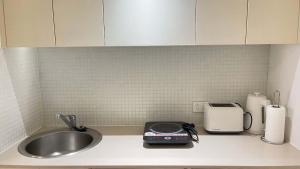 シドニーにあるMetaWise 2Bed on Dixon Next to ICC & Darling Harbour 65の- キッチンカウンター(シンク、トースター付)
