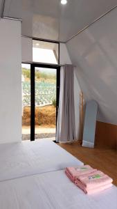 a bedroom with a bed with two towels on it at Dcahhya Family Cabin Villa The Sunrise View in Magelang
