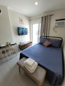 a bedroom with a blue bed and a table at Casa Carlito in Angeles