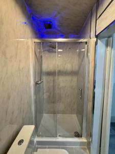 een douche met een glazen deur in een badkamer bij Oxborne Rooms UK - Plaistow in Londen