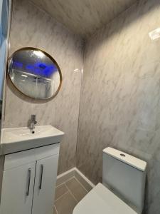 een badkamer met een wit toilet en een spiegel bij Oxborne Rooms UK - Plaistow in Londen