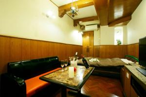 Zimmer mit einem Tisch und einem Bett im Hintergrund in der Unterkunft HotelD 大宮店 in Saitama