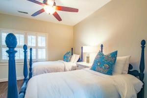 zwei Betten in einem Schlafzimmer mit Deckenventilator in der Unterkunft Green Winged Teal in Kiawah Island