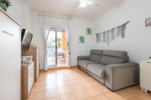 a living room with a couch and a tv at VERDEMAR 3, PLAYA HONDA in Cabo de Palos