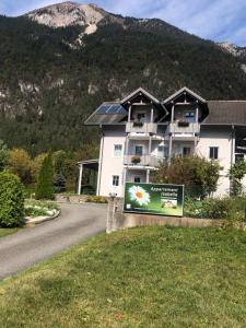 a sign in front of a house with a mountain at Appartment Isabelle Sky in Presseggersee