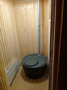 a bathroom with a black toilet in a wooden room at Aurora Chamber in Rovaniemi