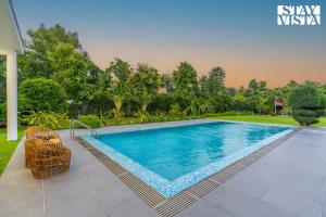 a swimming pool in the backyard of a house at StayVista at Imperial Isle 4BHK villa in Sohna with Comp BF, Pool, BBQ, Bonfire and Lawn, Ideal of parties & Events in Sohna