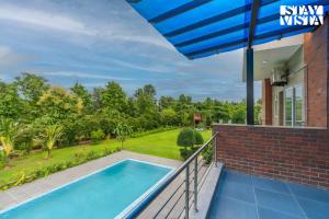 a view from the balcony of a house with a swimming pool at StayVista at Imperial Isle 4BHK villa in Sohna with Comp BF, Pool, BBQ, Bonfire and Lawn, Ideal of parties & Events in Sohna