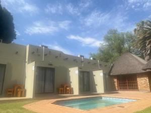 a house with a swimming pool in front of it at Grace to Grace Guest House in Klerksdorp