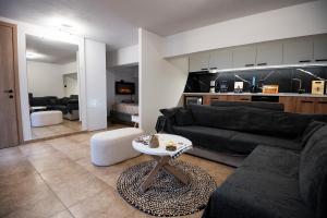 a living room with a black couch and a table at To Bee or not to Bee! in Volos