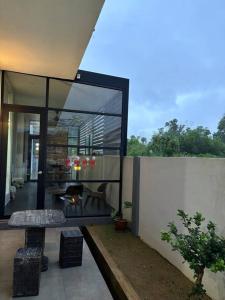 a glass house with a bench and a fireplace at Kuantan Bungalow PS4 16 Pax Kids Pool in Kuantan