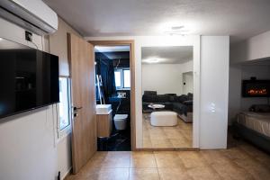 a room with a living room with a couch and a television at To Bee or not to Bee! in Volos +25 photos