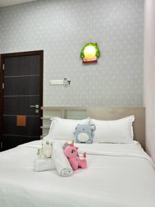 three stuffed animals are sitting on a bed at Kuantan Bungalow PS4 16 Pax Kids Pool in Kuantan +70 photos
