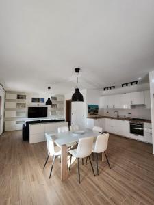 Una cocina blanca con una mesa y sillas blancas. en Salerno Marina Bay, en Salerno