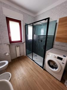 Un baño con inodoro y lavadora. en Salerno Marina Bay, en Salerno