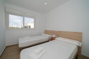 two beds in a room with a window at Valerie in Orihuela +21 photos