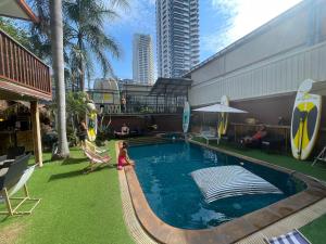 a girl is playing in a swimming pool in a building at Smokers Resort in Pattaya South