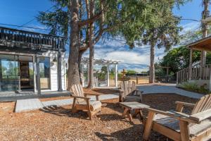 塞瓦斯托波尔Relaxing 3BR Home with Vineyard View Rooftop Deck and Game Room的一群椅子和一棵树,在一座建筑前