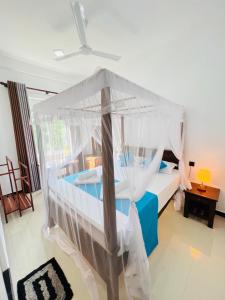 una camera da letto con un letto a baldacchino di JO Residence - Tangalle a Tangalle