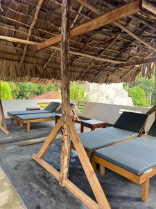un gruppo di letti sotto un ombrellone di paglia di JO Residence - Tangalle a Tangalle