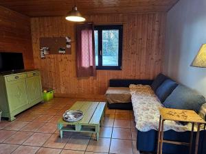 una sala de estar con un sofá y una mesa en Le Fayard - Chalet avec terrasse, en Mélisey 9 fotos más