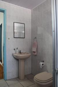 een badkamer met een wastafel, een toilet en een spiegel bij Hostel Imperial in Ouro Preto