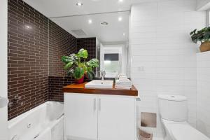 a bathroom with a sink and a toilet and a tub at Bay View Motel Number Four in Lorne