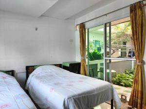 ein Schlafzimmer mit einem Bett und einem großen Fenster in der Unterkunft Nu Phuket Airport Resident 1 in Nai Yang Beach + 24 Fotos